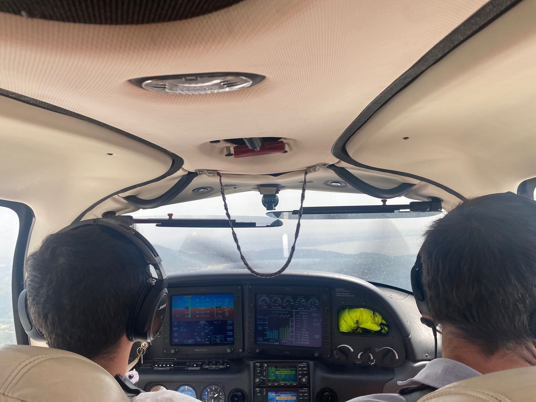 Passengers looking ahead at the cockpit instruments during flight